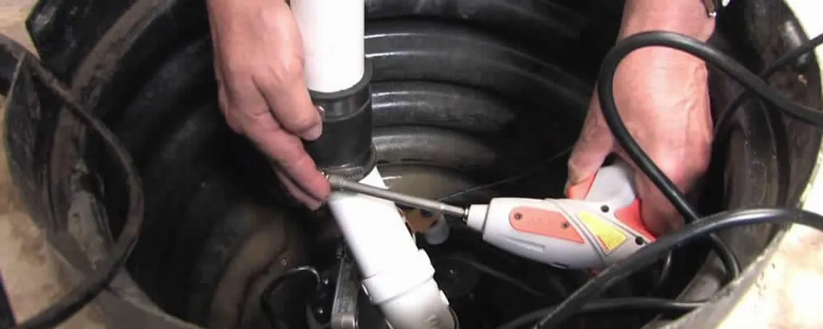 Sump pump installation technician connecting PVC discharge piping in Berkeley, CA